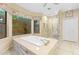 Bright bathroom with a soaking tub, a window overlooking the backyard, and a glass enclosed tile shower at 4066 E Grandview St, Mesa, AZ 85205