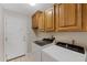 Bright laundry room with a washer, a dryer, and upper wood cabinets at 4066 E Grandview St, Mesa, AZ 85205