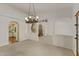 An elegant living space featuring high ceilings, chandelier and seamless access to the kitchen and backyard at 4066 E Grandview St, Mesa, AZ 85205