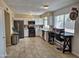 Renovated kitchen with stainless steel appliances, white cabinets, breakfast bar, and plenty of natural light at 4231 E Roeser Rd, Phoenix, AZ 85040
