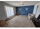 Spacious living room with tile floors, blue accent wall and large window with wooden accents at 4231 E Roeser Rd, Phoenix, AZ 85040