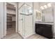 Bathroom featuring a glass enclosed shower with a bench seat, dark cabinets and tile accents at 4444 E Bethena St, Gilbert, AZ 85295