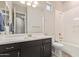 Bathroom with a large mirror, dark cabinets, and a shower-tub combo at 4444 E Bethena St, Gilbert, AZ 85295