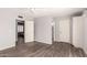Spacious bedroom with wood-look floors, light gray walls, two entryways, and overhead fan at 4701 E Walatowa St, Phoenix, AZ 85044