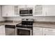 Close-up of modern stainless steel appliances, including oven, microwave, and dishwasher, set against granite countertops at 4701 E Walatowa St, Phoenix, AZ 85044