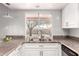 Stylish kitchen sink with granite countertops and a window view of backyard at 4701 E Walatowa St, Phoenix, AZ 85044
