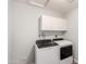 Laundry room featuring a modern washer and dryer with white cabinets, offering convenience and organization at 4701 E Walatowa St, Phoenix, AZ 85044