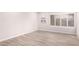 Empty room with wood-look tile flooring, modern lighting, and shuttered window at 4701 E Walatowa St, Phoenix, AZ 85044