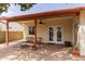 Covered patio with ceiling fan, brick flooring, and access to the home through double doors at 4701 E Walatowa St, Phoenix, AZ 85044