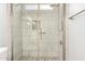 Modern shower featuring sleek glass doors, white tile, and a pebble floor at 4701 E Walatowa St, Phoenix, AZ 85044