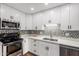 Kitchen featuring stainless steel appliances, mosaic tile backsplash, and white cabinets at 5525 E Thomas Rd # K6, Phoenix, AZ 85018
