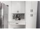Kitchen coffee bar with stainless steel fridge, white cabinets and drawers and mosaic backsplash at 5525 E Thomas Rd # K6, Phoenix, AZ 85018