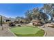 Lush backyard with a putting green and unique rock features and native desert landscaping at 6527 W Bloomfield Rd, Glendale, AZ 85304