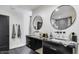 Modern bathroom featuring double sinks, black hardware, and decorative mirrors at 6527 W Bloomfield Rd, Glendale, AZ 85304