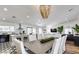 Open concept dining room features modern chandelier, long wood table and seating for ten at 6527 W Bloomfield Rd, Glendale, AZ 85304