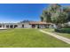Expansive front yard with a well-maintained lawn and charming single-story home featuring mature landscaping at 6527 W Bloomfield Rd, Glendale, AZ 85304