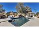 Backyard pool and waterfall feature blue tiling and a small gazebo in the distance at 6527 W Bloomfield Rd, Glendale, AZ 85304