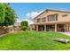 Expansive backyard with lush green grass, covered patio, and outdoor seating areas at 6963 W Aurora Dr, Glendale, AZ 85308