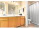 Bright bathroom with a wooden vanity, spacious mirror, and a shower-tub combo at 6963 W Aurora Dr, Glendale, AZ 85308