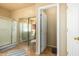 Bathroom with a large glass enclosed shower, mirrored closet, and neutral tile flooring at 6963 W Aurora Dr, Glendale, AZ 85308