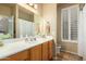 Clean bathroom featuring a wood vanity, framed mirror, and a shower-tub combination at 6963 W Aurora Dr, Glendale, AZ 85308