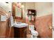 Charming powder room featuring a pedestal sink, decorative mirror, and warm color palette at 6963 W Aurora Dr, Glendale, AZ 85308