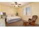 Cozy bedroom with a ceiling fan, plantation shutters and a comfortable rocking chair at 6963 W Aurora Dr, Glendale, AZ 85308