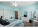 Bright bedroom with turquoise walls and ceiling fan, complemented by wicker furniture at 6963 W Aurora Dr, Glendale, AZ 85308