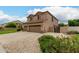 Spacious front yard shows desert landscaping and a three-car garage at 6963 W Aurora Dr, Glendale, AZ 85308