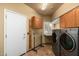 Well-lit laundry room featuring modern washer and dryer, storage cabinets, and tiled floors at 6963 W Aurora Dr, Glendale, AZ 85308