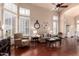 Sunlit living room with hardwood floors, neutral decor, and large windows with white shutters at 6963 W Aurora Dr, Glendale, AZ 85308