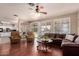 Open concept living room featuring hardwood floors, ample lighting, and a seamless flow to the kitchen at 6963 W Aurora Dr, Glendale, AZ 85308