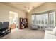 Comfortable living room with ceiling fan, cozy seating, and a view into the bathroom at 6963 W Aurora Dr, Glendale, AZ 85308