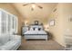 Well-lit bedroom with a ceiling fan, a large bed, and neutral tones for a relaxing ambiance at 6963 W Aurora Dr, Glendale, AZ 85308