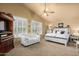 Bright main bedroom featuring large windows, a comfortable seating area, and a ceiling fan at 6963 W Aurora Dr, Glendale, AZ 85308