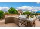 Outdoor kitchen featuring a built-in grill, sink, and bar area, ideal for backyard entertaining at 6963 W Aurora Dr, Glendale, AZ 85308