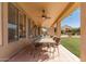Covered patio with a ceiling fan and outdoor dining area overlooking the backyard at 6963 W Aurora Dr, Glendale, AZ 85308