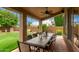 Covered outdoor patio with a large dining table and view of the landscaped backyard at 6963 W Aurora Dr, Glendale, AZ 85308