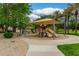 Community playground with slides and shade structure on a paved walkway surrounded by green landscaping at 6963 W Aurora Dr, Glendale, AZ 85308