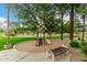 Small community playground with a slide and bench surrounded by lush green grass and palm trees at 6963 W Aurora Dr, Glendale, AZ 85308