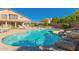 Inviting backyard pool with rock waterfall, lush landscaping, and lounge area at 6963 W Aurora Dr, Glendale, AZ 85308