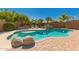 Beautiful backyard pool with rock features, palm trees, and lounge chairs at 6963 W Aurora Dr, Glendale, AZ 85308