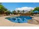 Inviting backyard pool with lush tropical landscaping, rock waterfall feature, and lounge chairs at 6963 W Aurora Dr, Glendale, AZ 85308