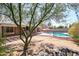 Spacious backyard with a sparkling pool, rock features, and mature tree at 7138 W Sierra Vista W Dr, Glendale, AZ 85303