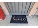 Welcoming doormat at the front door says, 