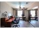 Functional home office featuring a ceiling fan, dark wood desks, and tile flooring at 7138 W Sierra Vista W Dr, Glendale, AZ 85303