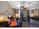 Bright home office with a ceiling fan, dark wood desks, and large mirror closet doors at 7138 W Sierra Vista W Dr, Glendale, AZ 85303