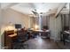 Bright home office with a ceiling fan, dark wood desks, and sliding mirror closet doors at 7138 W Sierra Vista W Dr, Glendale, AZ 85303