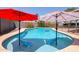 Sparkling in-ground pool with colorful sun umbrellas providing shade at 7138 W Sierra Vista W Dr, Glendale, AZ 85303