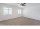 Sunlit bedroom with a ceiling fan, carpet flooring, and shuttered windows providing natural light at 726 W El Camino W Dr, Phoenix, AZ 85021